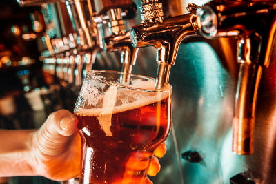 Beer pours into a glass from a tap at a bar