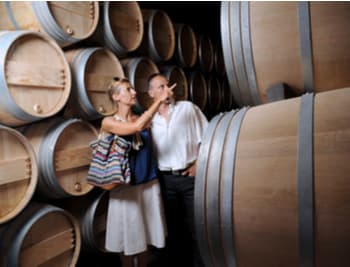 people walking among wine barrels